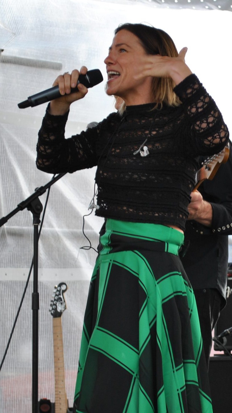 Claire Bender singing live with a handheld microphone